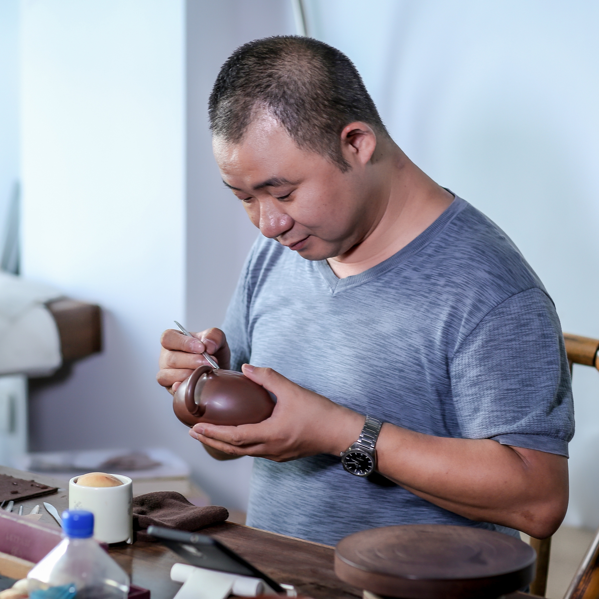 Сотрудник компании Yixing Aiii Art Ceramics Co., Ltd. за работой.